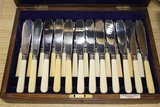 A cased set of twelve pairs of plated fish knives and forks with servers, silver banded ivorine handles